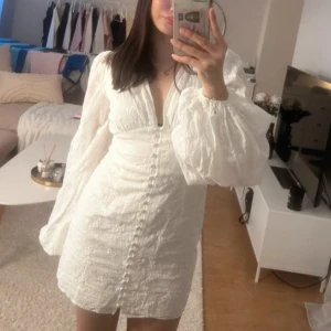 Vit Studentklänning Adoore - Säljer denna Adoore klänningen i stl 36(små i storlek) oanvänd då jag bestämt mig för en annan inför studenten. Den är cirka 2/3 cm utsydd i sidorna vilket inte syns fram eller bak ifrån då jag är idrottare behövde jag nån cm till över ryggen , där av priset💘 Stygnen är satta med möjlighet att ta bort lätt😊 NYPRIS 1499kr