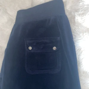 Mörkblå mjukisbyxor från Juicy Couture - Säljer ett par mörkblå juicy couture byxor. Jätte sköna men kommer tyvärr aldrig till användning. Har ett skumt material på ena framfickan som syns på bild, men det kom när jag beställde dem. ❤️