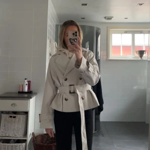 Kort beige trenchcoat  - Sååå fin trenchcoat från Nelly. Endast provad!! 