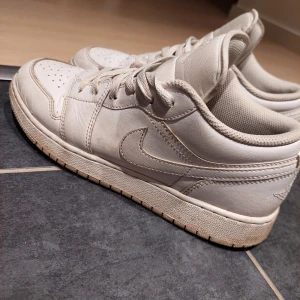 Vita Nike Air Jordans - Ny pris 1900kr! Säljer ett par vita Nike Air Jordans med klassisk design och snörning. Skorna har en stilren look med det ikoniska Air Jordan-märket på tungan och hälen. Perfekta för dig som vill ha en tidlös sneakerstil.