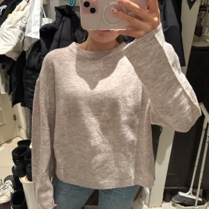 Beige stickad tröja från 157 - Säljer en mysig beige stickad tröja från 157. Den är enkel och stilren, vilket gör den lätt att matcha med olika outfits.