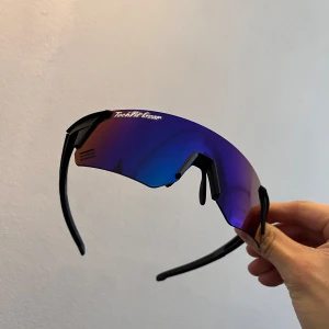 Sportiga solglasögon från TechFit Gear - Snygga och sportiga solglasögon från TechFit Gear med en spegelblå lins och svart båge. Perfekta för utomhusaktiviteter med en modern och aerodynamisk design.