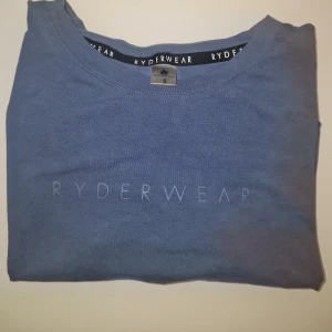Blå croppad t-shirt från Ryderwear - Säljer en blå croppad träninngs t-shirt från Ryderwear. Använd 2-3 gånger.