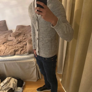 Grå stickad kofta med knappar - Grå stickad kofta i fint skick! Klassisk design med knappar och fickor. Perfekt för vardag eller uppklätt. Skön och stilren. Storek S  Skicka PM vid intresse!