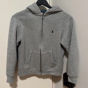 Grå hoodie från Ralph Lauren - Säljer en klassisk grå hoodie från Ralph Lauren med dragkedja.