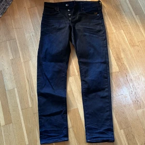 Mörkblå jeans från G-Star RAW - Snygga mörkblå jeans från G-Star RAW med en regular tapered passform. De har en knappgylf och klassiska femficksdetaljer. Perfekta för en stilren look.