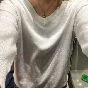 Vit v-ringad tröja från Zara - Säljer en stilren vit v-ringad tröja från Zara. Perfekt för en enkel och elegant look. Tröjan har långa ärmar och är gjord i ett mjukt material som känns skönt mot huden. Passar bra till både jeans och kjol.