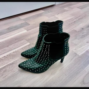 Svarta boots med nitar - Snygga gröna boots med spetsig tå och klack. Dekorerade med silverfärgade nitar som ger en tuff look. Perfekta för att lyfta vilken outfit som helst.