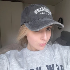 keps - Snygg svart keps med broderad text framtill. Perfekt för en avslappnad stil och skydd mot solen. Justerbar passform för optimal komfort.