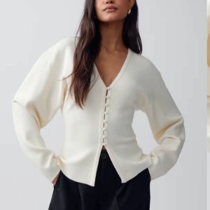 Vit kofta/tröja från Gina Tricot - Snygg vit kofta från Gina Tricot med v-ringning och knappar framtill. Perfekt för en stilren look. Helt oanvänd, då den inte passade mig Storlek S