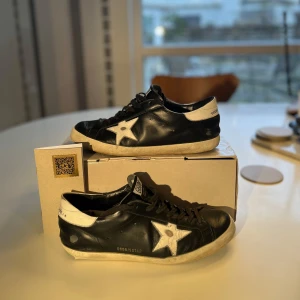 Golden goose - Ett par riktigt schyssta golden goose skor i färgen svart⚫️| Skick-7/10✅| Skorna har en skada på båda skorna där bak men fungerar ändå att gå med utmärkt, original box och golden goose passport följer med. Riktigt bra pris men ändån inte hugget i sten. 🪨 skriv vid vidare funderingar 