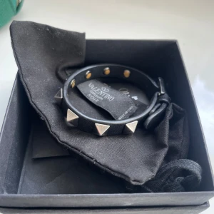 Valentino armband - Snyggt svart läderarmband från Valentino med  nitar. Säljer då jag inte längre använder, justerbart. Köptes på NK för 1700