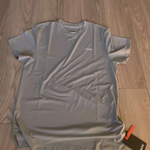 Grå t-shirt från Nox - grå t-shirt från Nox med korta ärmar och rund hals. Perfekt för träning. Tillverkad i ett mjukt och bekvämt material. Passar inte mig.