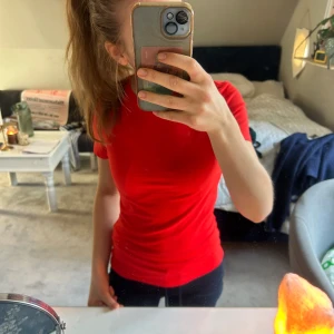 Röd tajtare t-shirt  - Säljer en snygg röd t-shirt med tajtare passform från Monki. Helt oanvänd och ny. Storlek XS