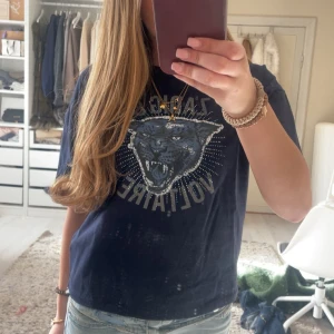Mörkblå t-shirt från Zadig & Voltaire - Snygg mörkblå t-shirt från Zadig & Voltaire med ett coolt tryck av ett panterhuvud och texten 'Zadig & Voltaire' i vitt. Perfekt för en avslappnad stil med en touch av edge.