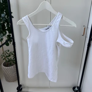 Vit oneshoulder linnetopp från Weekday - Säljer en stilren vit oneshoulder linnetopp från Weekday. Perfekt för en trendig look med sin unika axelbandsdesign. Tillverkad i mjukt material för en bekväm passform. Passar utmärkt till både jeans och kjol!