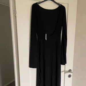 Svart långklänning från Boohoo 170-180cm - Elegant svart långklänning från Boohoo med långärmad design och en djup, öppen rygg. Perfekt för en stilren och sofistikerad look. Passar dig som är lite längre, mjukt material