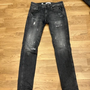 Grå/svarta replay jeans med slitningar 31/34 - Säljer nu dessa riktigt snygga Replay Anbass jeans! 🤩Den gråa och svarta tvätten är väldigt snygg tillsammans med några slitningar. Dom är i mycket bra skick, inga tecken på användning. Slim fit storlek 31/34. Tveka inte att skriva om det uppkommer några frågor!😄