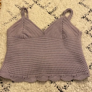 Lila stickad linnetopp från Amisu - Säljer en söt lila stickad linnetopp från Amisu. Toppen har justerbara axelband och en fin vågig kant nedtill. Perfekt för varma dagar eller som ett lager under en kofta.