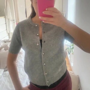 Grå kofta med pärlknappar - Säljer en stilren grå kofta med korta ärmar och pärlknappar. Passar bra till både jeans och kjol. Knappt använd 