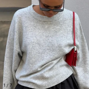 Grå stickad tröja - Mysig grå stickad tröja med rund hals och långa ärmar. Perfekt för kyliga dagar med sin mjuka och bekväma passform. Ribbstickade muddar vid ärmslut och nederkant ger en stilren look.