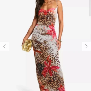 Leopardmönstrad långklänning med blommor - Snygg långklänning med leopardmönster och stora röda blommor. Aldrig använd 