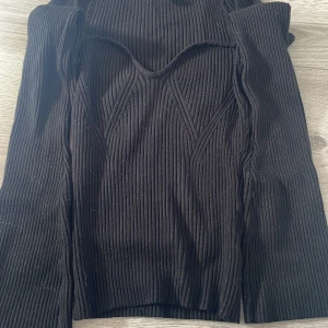 Svart ribbad tröja från H&M - Säljer en svart ribbad tröja från H&M. Har utsvängda armar.
