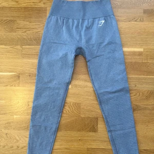 Gymshark träningstights - Blåa träningstights från Gymshark , Vital Seamless , lite sprucket vid märket men inte mycket. Storlekslapp bortklippt men passar mig med XS men känns lite större än dem jag har i XS, men passar mig bra ändå.