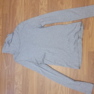 Grå polotröja i bomull från Ralph Lauren - Säljer en enkel och stilren grå polotröja med långa ärmar. Tröjan är i mjukt bomullsmaterial och passar perfekt till lager-på-lager eller som den är. Klassisk modell med normal passform.