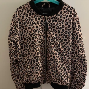 Leopardmönstrad bomberjacka från FB Sister - Säljer en snygg bomberjacka från FB Sister i leopardmönster. Jackan har dragkedja framtill, svarta muddar och krage samt en ficka på ärmen. Materialet är syntet och insidan är fodrad med svart tyg.