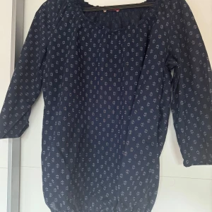 En mörkblå blus med trekvartsärmar  - En mörkblå blus med trekvartsärmar. 