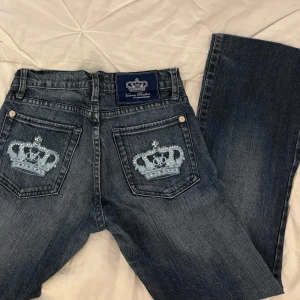 Lågmidjade jeans Victoria Beckham  - Lågmidjade jeans från Victoria Beckham med kronor på bakfickorna. 