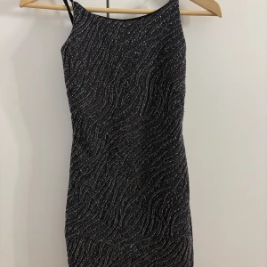 Svart glittrig kortklänning från Chiquelle - Säljer en svart glittrig kortklänning från Chiquelle med smala axelband, passar mig som har storlek S.