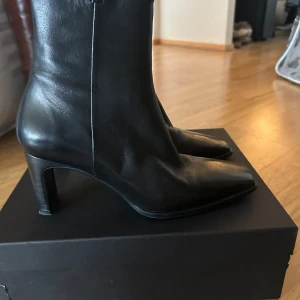 Svarta skinnstövletter med klack från Billi Bi - Säljer ett par svarta stövletter i skinn från Billi Bi. Skorna har spetsig tå, medelklack och dragkedja på sidan. De är knappt använda så otroligt bra skick. De är i äkta skinn så kommer hålla otroligt länge.
