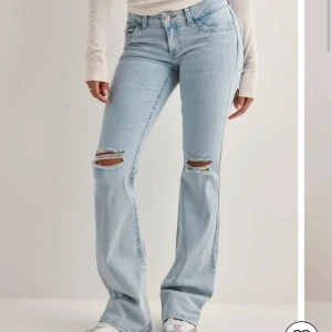 Ljusblå bootcut jeans  - Säljer ett par ljusblå bootcut jeans med slitna detaljer vid knäna och broderade bakfickor. Jeansen har normal passform men jeansen är uppsydda ca 5-8cm! Passar nog till 168cm skulle jag säga. .  ¡SKRIV INNAN OM NI SKA KÖPA! 