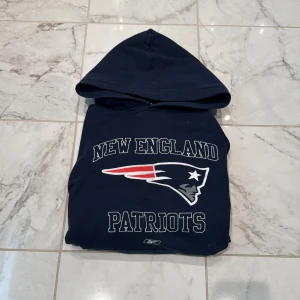 Mörkblå New England Patriots hoodie - Säljer en mörkblå hoodie med New England Patriots tryck på bröstet. Tröjan har huva och klassisk sportig stil, perfekt för dig som gillar amerikansk fotboll och vill ha en bekväm och snygg tröja. Riktigt skön hoodie💯