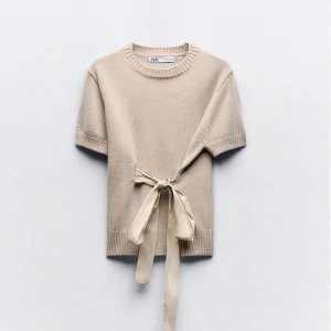 Beige stickad topp med knytband från Zara - Superfin beige stickad topp från Zara med korta ärmar och ett snyggt knytband i midjan. Perfekt till jeans eller kjol för en stilren look. Mjuk och skön kvalitet med rund halsringning. Storlek L men passar för xs-m🩷Jag brukar ha storlek xs och det passar mig bra (bild 3) 