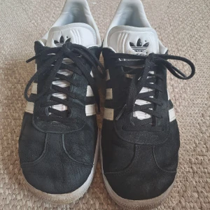 Adidas Gazeller - Adidas Gazeller, använda förra sommaren men har tyvärr blivit för små. Ganska slita men så sköna fortfarande. Har inga defekter förutom att de är smutsiga och slitna💕 Storlek 42 2/3