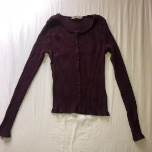 Mörklila ribbad kofta med knappar - Säljer en mörklila ribbad kofta med långa ärmar och knappar framtill. (Knapparna är ej riktiga som man ser på bild 3)