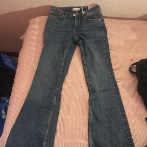 Low waist jeans från Gina med prislapp kvar - Klassiska blå Levis 501 jeans med raka ben och hög midja. Jeansen har fem fickor, knappgylf och är tillverkade i robust denim. Perfekta för en avslappnad och tidlös stil.
