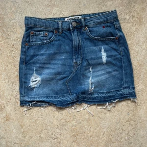 Blå jeanskjol med slitningar från Tally Weijl - Säljer en blå jeanskjol från Tally Weijl med slitna detaljer och fransig nederkant💗