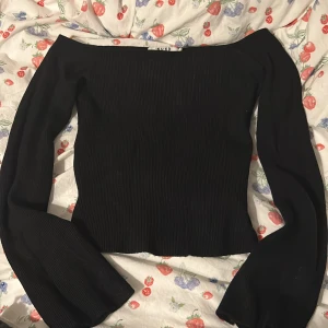 Svart ribbad offshoulder-top från NA-KD - Trendig svart ribbad topp från NA-KD med offshoulder-modell och långa ärmar. Helt ny utan prislapp 🫶🏼🫶🏼