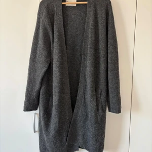 Mörkgrå stickad kofta - Mysig, stor och lång kofta som funkar att dra på när man fryser lite. 