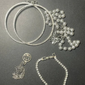 Mix av silversmycken och pärlor - Säljer ett kit med stora glittriga hoops i silverfärg, ett armband med gnistrande stenar, ett halsband med pärlor och en silverkedja med rund berlock. Perfekt för dig som gillar att mixa olika stilar och accessoarer.