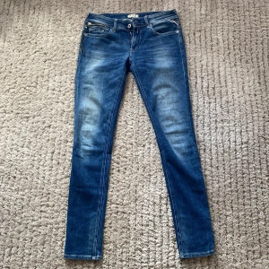 Replay Anbass skinny jeans blå - Snygga blå Replay Anbass jeans med skinny fit och klassisk femficksdesign. Jeansen har dragkedjedetalj vid fickan och slitningar för en cool look. Tillverkade i stretchig denim som sitter tajt och bekvämt hela dagen.