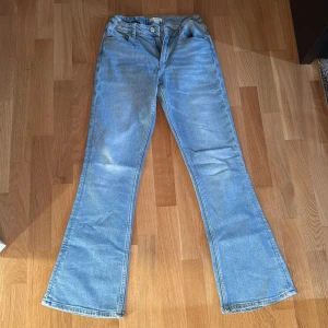 Ljusblå low waist bootcut jeans - Bootcut jeans från gina i nyskick , går att justera de är ananrs i strl 164 -xs 