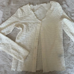 Blus med knappar - Superfin krämvit tröja med lång ärm och v-ringning. Från ASOS men har klippt av lappen, men gissar på att det är en storlek S