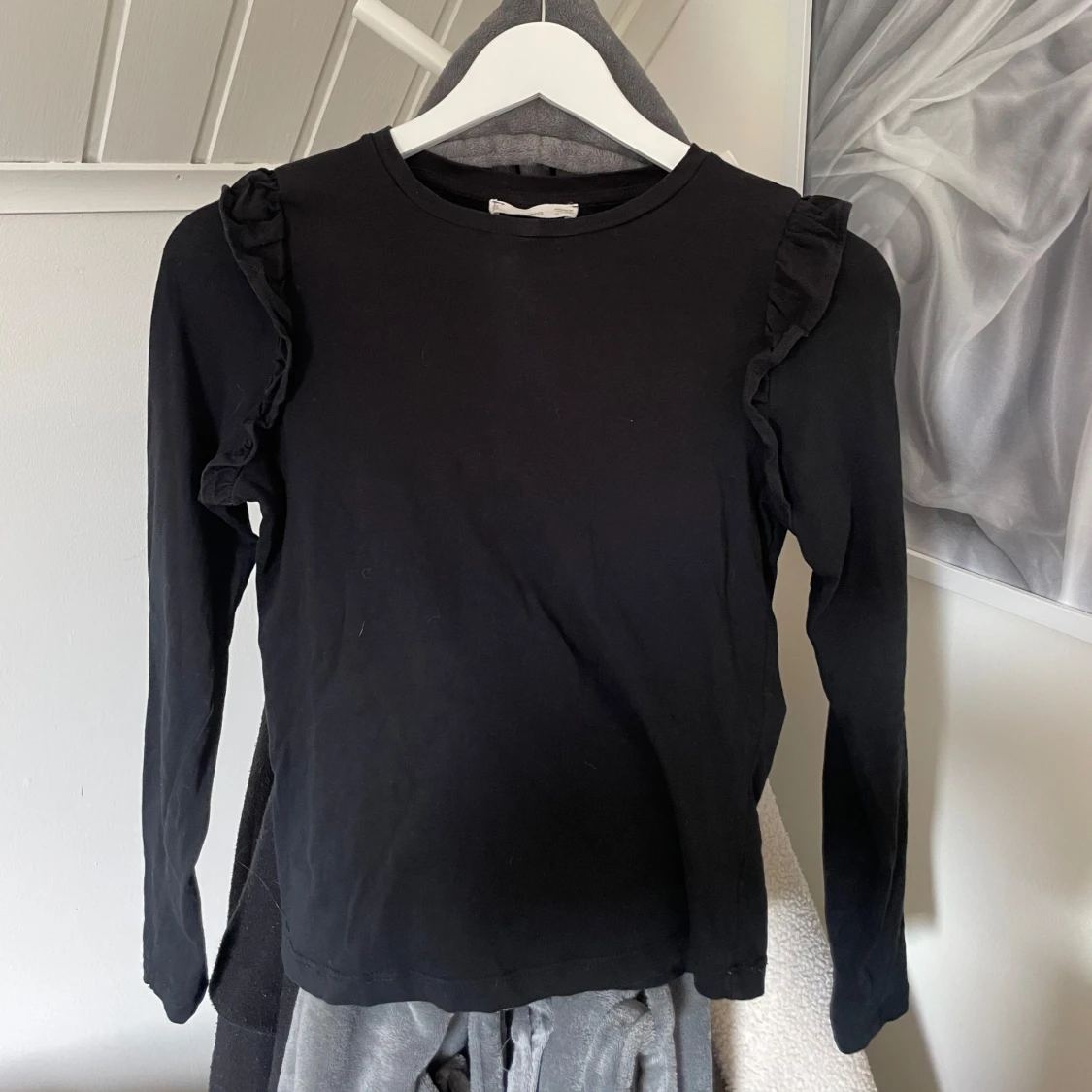 Svart långärmad topp med volang från MANGO