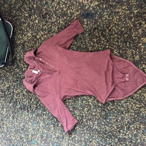 Ribbad brun body från Pretty Little Thing - Säljer en ribbad brun body från & other stories, den har knäppning framtill och är i ett stretchigt material som sitter snyggt. Perfekt att styla med jeans eller kjol för en trendig look.