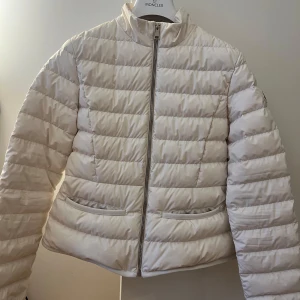 Moncler jacka - Säljer denna superfina Moncler jackan perfekt till vår/höst i en creme vit färg med fram. Endast testad så den är i perfekt skick! Den är i storlek 14yrs, vilket är som en xs/s. Jag har storlek S i kläder och den passar mig perfekt. Tillkommer med alla tillbehör samt kvitto🩷